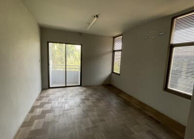 Empty bedroom with parquet flooring and windows