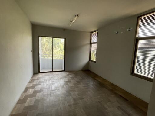 Empty bedroom with parquet flooring and windows