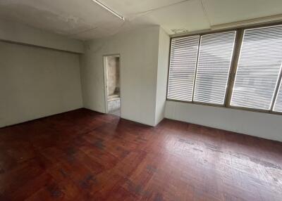 Spacious bedroom with wooden floors and large windows