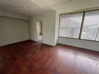 Spacious bedroom with wooden floors and large windows