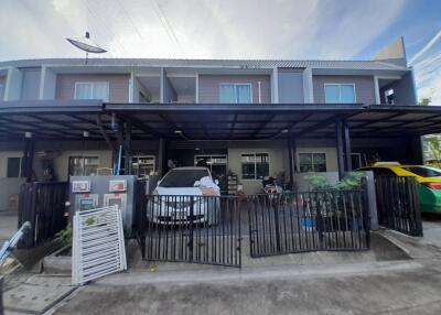 Facade of a townhouse with a carport