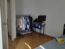 Bedroom with clothes rack and TV