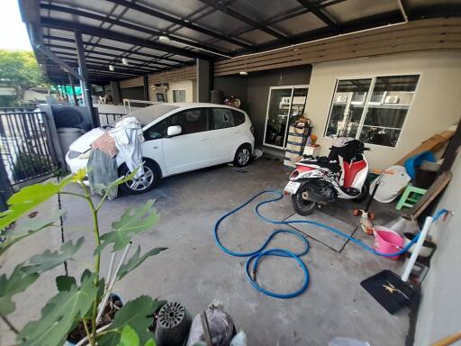 Covered garage area with a car and a scooter