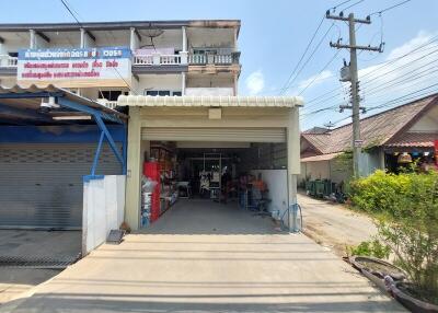 Exterior view of a commercial building with garage and adjacent shops