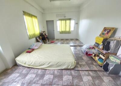 Simple bedroom with mattress, shelves, and tiled flooring