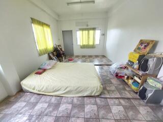 Simple bedroom with mattress, shelves, and tiled flooring