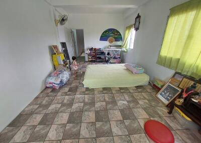 Bedroom with tiled floor, bed, and various items