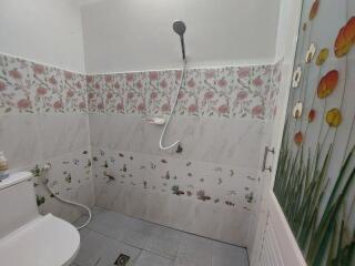 Bathroom with floral wall tiles and a shower