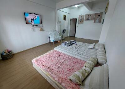 Bedroom with wall-mounted TV and simple bedding