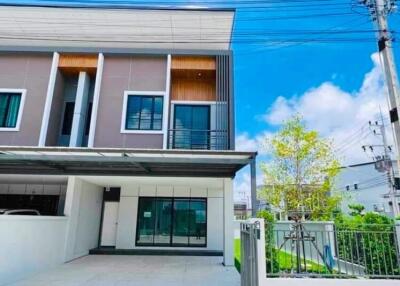 Modern two-story residential building with carport and fenced yard