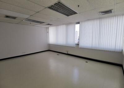 empty office with large windows and ceiling lights