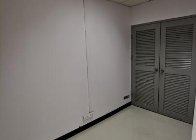 Small empty room with white walls, ceiling lights, and double door