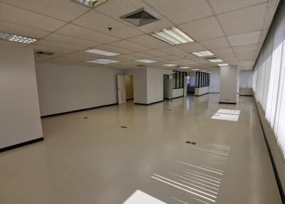 Spacious empty office area with large windows