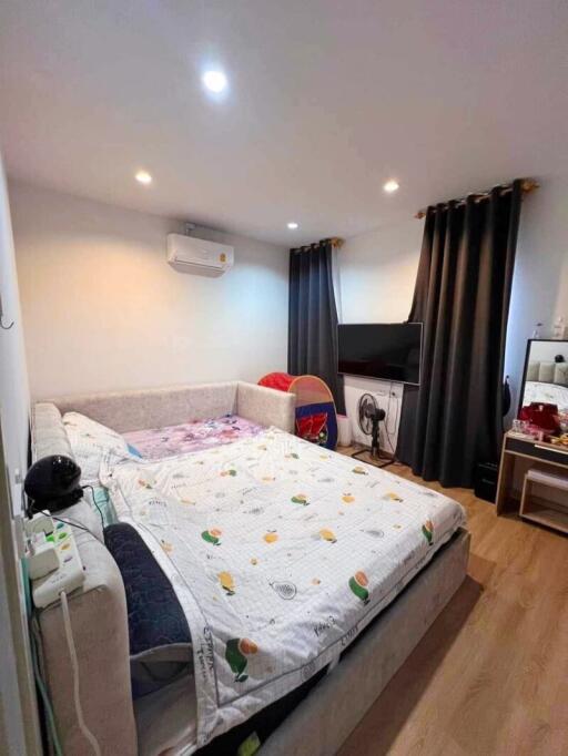 Bedroom with large bed, air conditioner, and TV