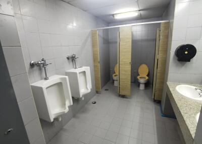 Public restroom with urinals, toilets, and a sink