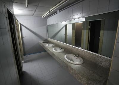 Spacious bathroom with three sinks and large mirror