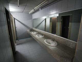 Spacious bathroom with three sinks and large mirror