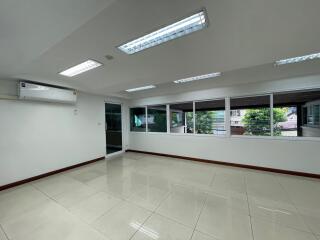 Spacious living room with large windows and tile flooring