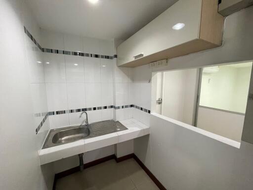 Small contemporary kitchen with sink and white cabinetry