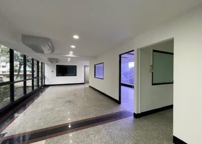 spacious office area with large windows and air conditioning units