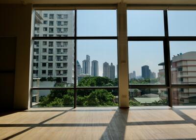 Spacious living room with large windows and city view