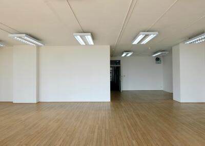 Spacious empty room with wooden flooring and white walls