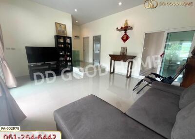 Modern living room with a TV, a sofa, a bookshelf, and decorative elements on the wall