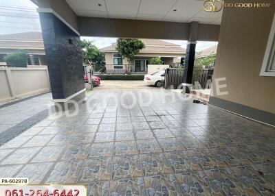 Covered garage area with paved floor and view of surrounding area