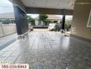 Covered garage area with paved floor and view of surrounding area