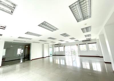 Spacious open office space with large windows and tiled flooring