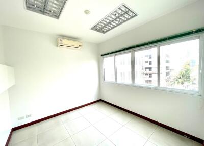 Empty bedroom with large windows and tiled flooring