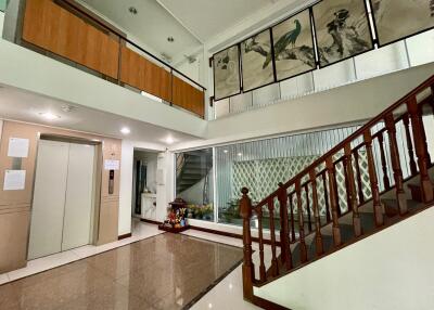 Spacious lobby with stairs and elevator