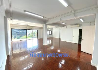 Spacious living room with large windows and polished wooden floor