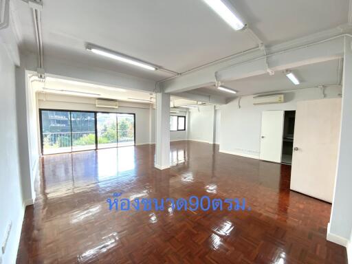 Spacious living room with large windows and polished wooden floor