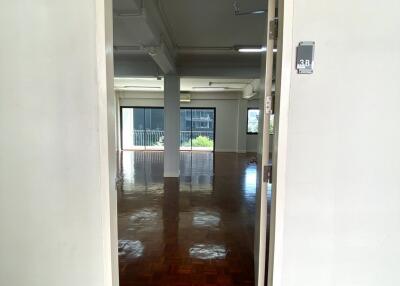 Entrance to a spacious room with hardwood floors and large windows