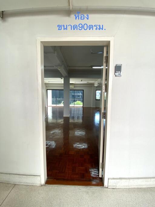 Entrance to a spacious room with hardwood floors and large windows