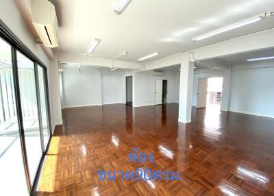 Spacious open-plan living area with wooden flooring and large windows