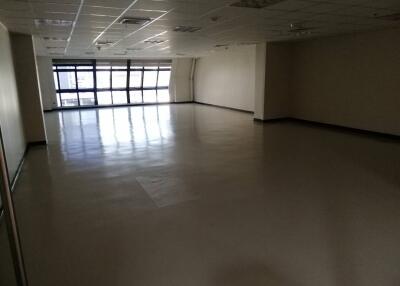 empty office space with large windows and tiled floor