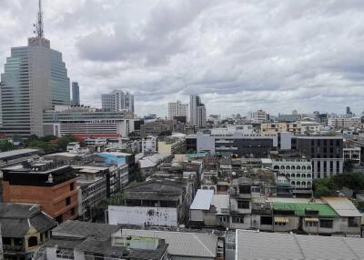 View of cityscape with multiple buildings under a cloudy sky
