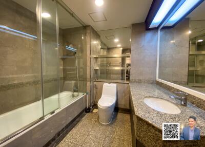 Modern bathroom with glass-enclosed shower, toilet, and vanity sink