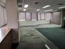 Empty office space with large windows and carpet flooring