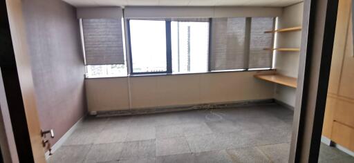 Empty office space with large windows and shelves