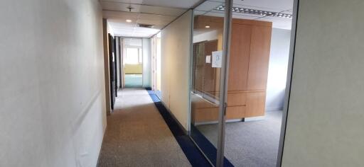 Office hallway with glass partitions and wooden cabinet