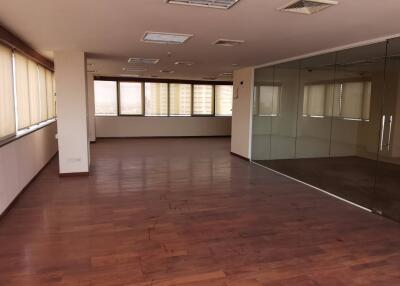 Empty office space with hardwood floors and large windows