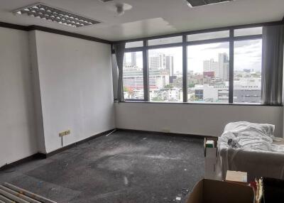 Partially furnished office with large windows