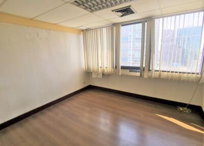 Empty office room with large windows and blinds