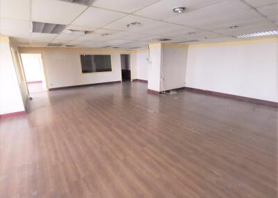 Large empty office space with wooden flooring and white walls