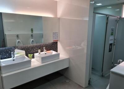 Modern public bathroom with double sinks and urinals