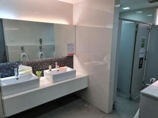 Modern public bathroom with double sinks and urinals