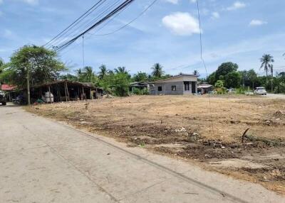 Vacant lot with a small house and surrounding buildings